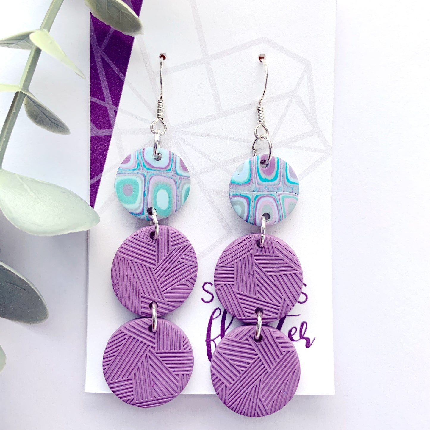 Three tiered circle drop earrings with two textured in purple and one teal/purple cane.
